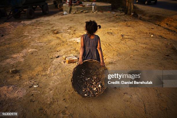 Indian children work nearby to their parents at a construction project in front of the Jawaharlal Nehru Stadium on January 30, 2010 in New Delhi,...
