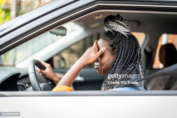 porträt von gestressten afrikanische frau im auto - man driving anxiously stock-fotos und bilder