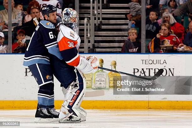 Cory Stillman of the Florida Panthers skates in tandem with goaltender Rich DiPietro of the New York Islanders at the BankAtlantic Center on January...