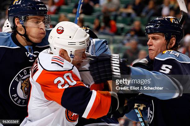David Booth of the Florida Panthers and teammate Bryan Allen tangle with Sean Bergenheim of the New York Islanders at the BankAtlantic Center on...