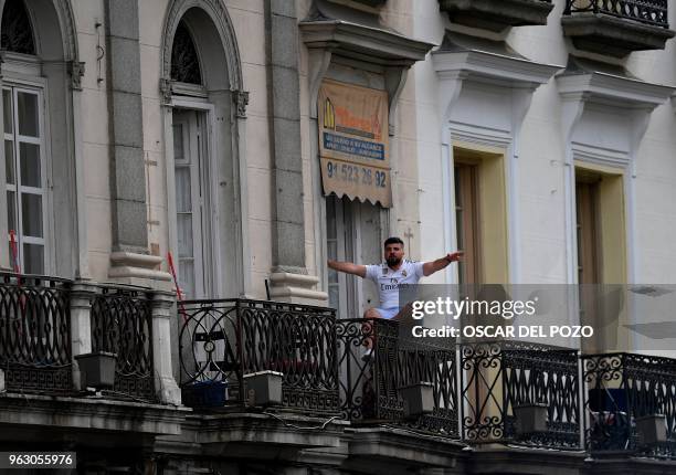 Real Madrid fan celebrates on a balcony at the Puerta del Sol square in Madrid on May 27, 2018 as he waits for Real Madrid´s football players parade...