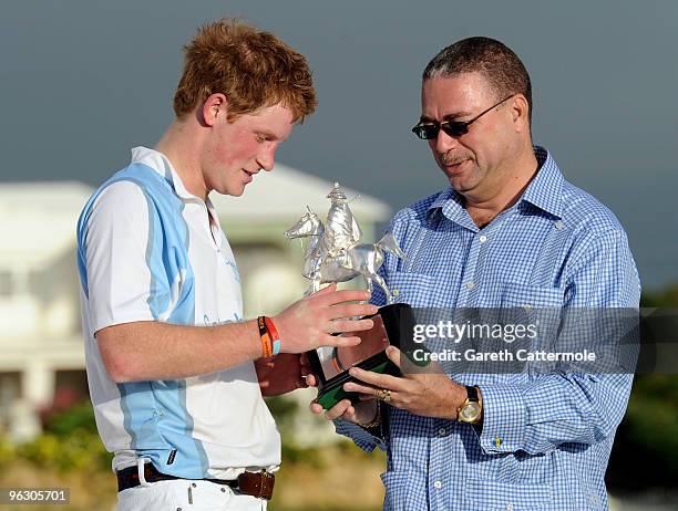 Prince Harry is presented with a trophy after the Prince's Sentebale team triumphed against South Africa in the Sentebale Polo Cup on January 31,...