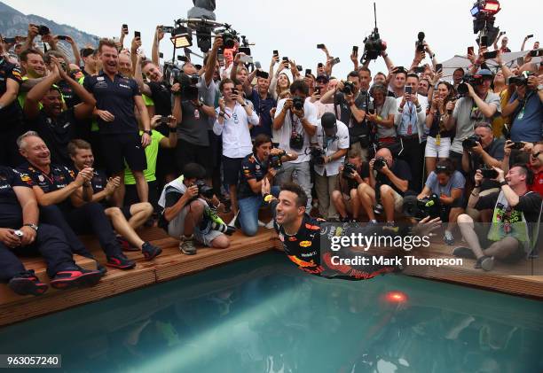Race winner Daniel Ricciardo of Australia and Red Bull Racing celebrates with a swan dive into the swimming pool of the Red Bull Energy Station after...