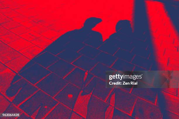 shadow of a man and woman on pavement on red background - abstract geometric silhouette woman stock pictures, royalty-free photos & images