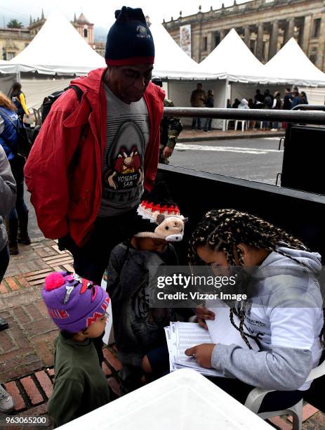 An employee of the National Civil Registry helps voters find their polling station during the Presidential Elections in Colombia on May 27, 2018 in...