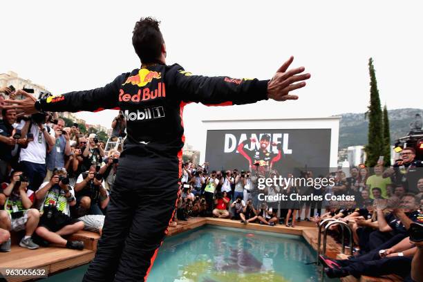 Race winner Daniel Ricciardo of Australia and Red Bull Racing celebrates with a swan dive into the swimming pool of the Red Bull Energy Station after...