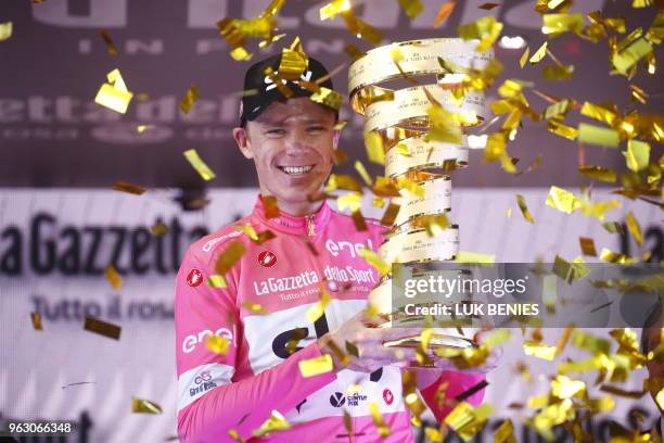 Pink jersey and winner, Britain's rider of team Sky Christopher Froome, poses with the trophy on the podium after the 21st and last stage of the...