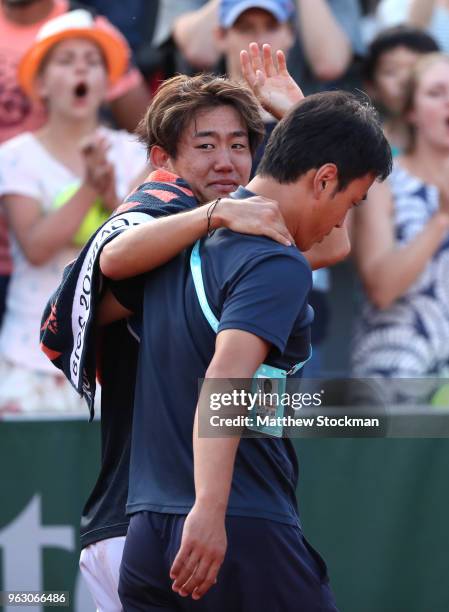 Yoshihito Nishioka of Japan shows his emotions as he is helped off the court following an injury in his mens singles first round match against...