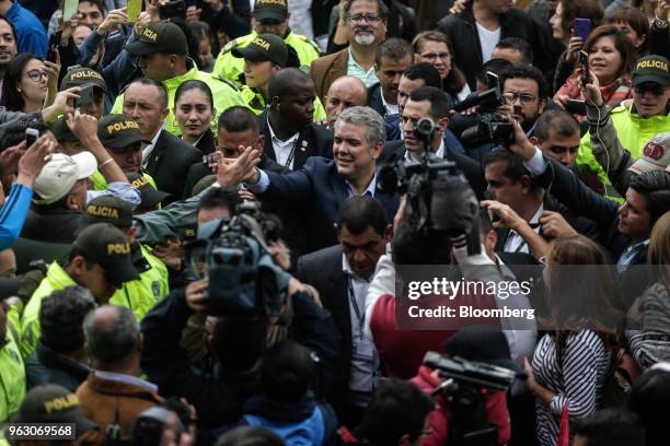 Ivan Duque, presidential candidate for the Democratic Center Party, center, greets voters after casting his ballot at the National Pedagogical...