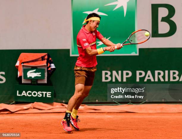 Kei Nishikori of Japan hits a backhand to Maxime Janvier of France in the first round of the French Open at Roland Garros on May 27, 2018 in Paris,...