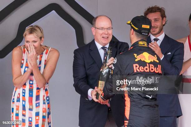 Race winner Daniel Ricciardo of Australia and Red Bull Racing shares his champagne with Prince Albert of Monaco and Princess Charlene of Monaco on...
