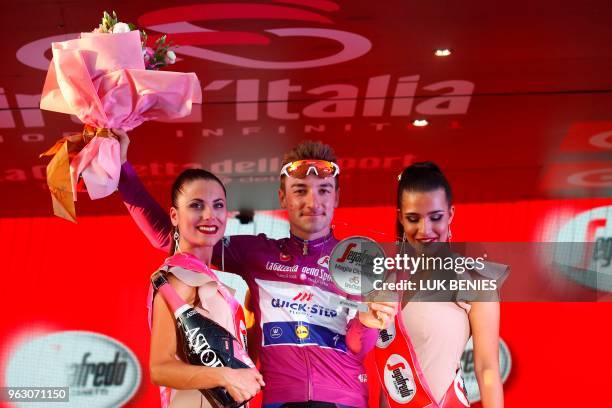 Italy's rider of team Quick-Step Elia Viviani celebrates the cyclamen jersey of the "sprinter classification leader" on the podium after the 21st and...