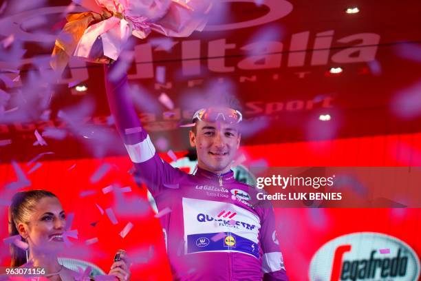 Italy's rider of team Quick-Step Elia Viviani celebrates the cyclamen jersey of the "sprinter classification leader" on the podium after the 21st and...