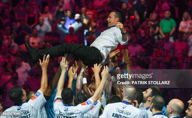 Montpellier's players throw headcoach Patrice Canayer in the air after winning the Final match HBC Nantes vs HB Montpellier at the EHF Pokal men's...