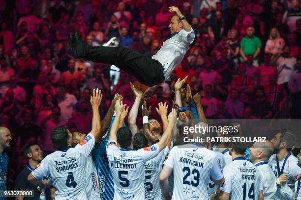 Montpellier's players throw headcoach Patrice Canayer in the air after winning the Final match HBC Nantes vs HB Montpellier at the EHF Pokal men's...