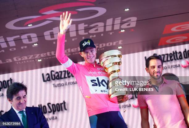 Pink jersey and winner, Britain's rider of team Sky Christopher Froome celebrates with the trophy next to Spain's former professional cyclist Alberto...