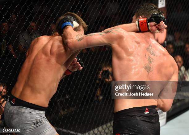 Stephen Thompson punches Darren Till of England in their welterweight bout during the UFC Fight Night event at ECHO Arena on May 27, 2018 in...