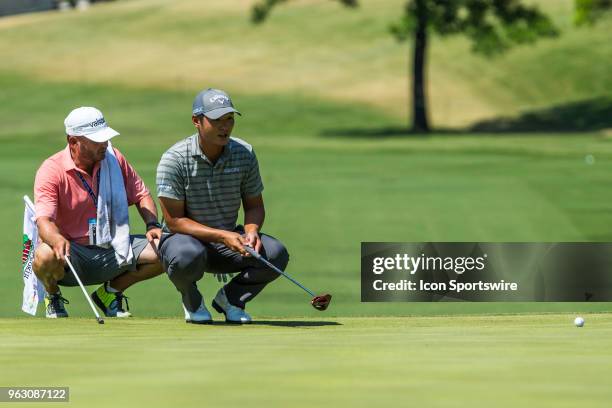 John Huh and his caddie lines up his putt during the final round of the Fort Worth Invitational at the Colonial Country Club in Fort Worth, Texas.