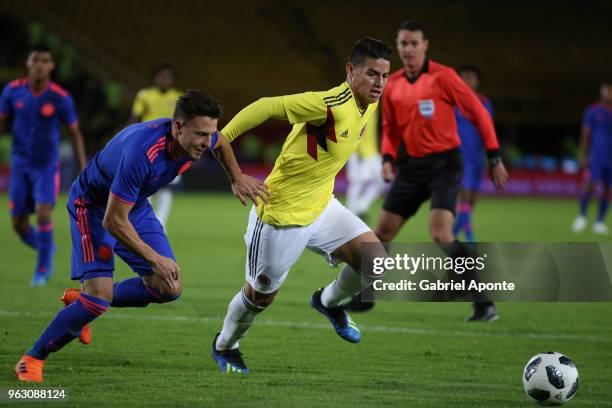 Santiago Arias and James Rodriguez of Colombia fight for the ball during a training session open to the public as part of the preparation for FIFA...