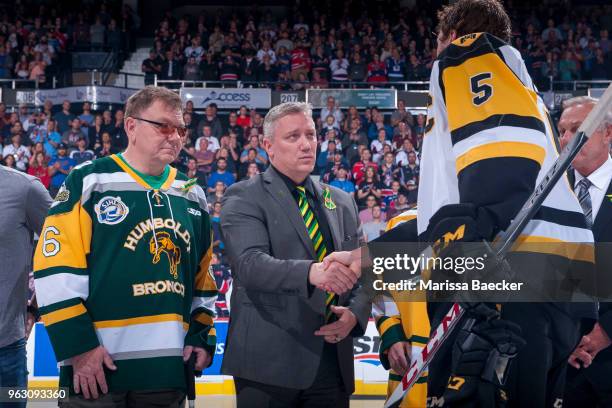 Lyle Brons, and Kevin Garinger, president of the Humboldt Broncos stand at centre ice for the ceremonial puck drop between Regina Pats and Hamilton...