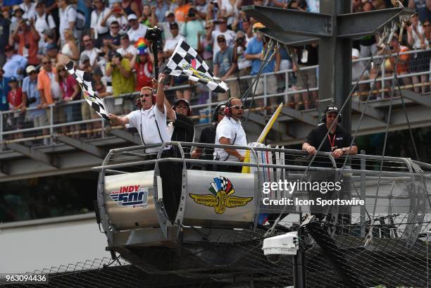 Checkered flags fly at the conclusion of the IndyCar Series Indianapolis 500 on May 27 at the Indianapolis Motor Speedway in Indianapolis, Indiana.