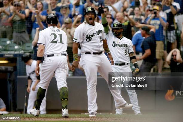 Travis Shaw and Jesus Aguilar of the Milwaukee Brewers celebrate after scoring runs in the seventh inning against the New York Mets at Miller Park on...