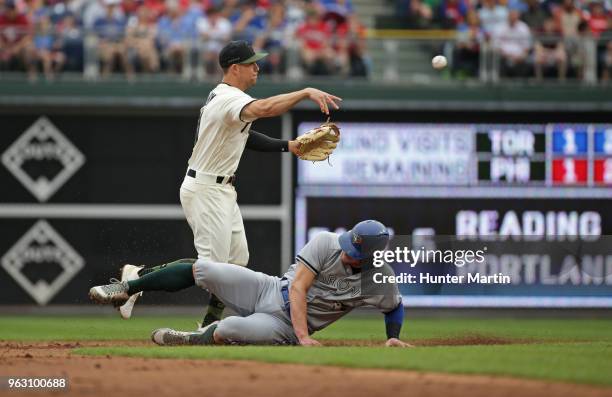 Scott Kingery of the Philadelphia Phillies turns a double play as Josh Donaldson of the Toronto Blue Jays slides under the throw in the third inning...