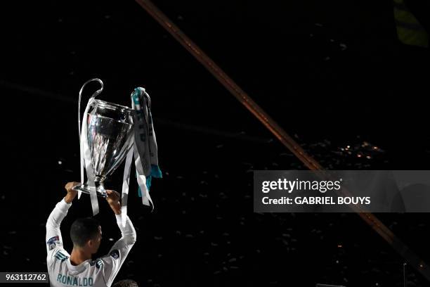 Real Madrid's Portuguese forward Cristiano Ronaldo holds the trophy at the Santiago Bernabeu stadium in Madrid on May 27, 2018 during a victory...