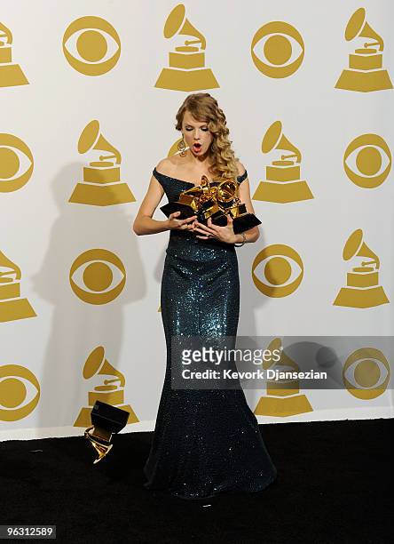Singer Taylor Swift drops a Grammy award while pose with Album Of The Year award for 'Fearless', Best Female Country Vocal Performance for 'White...