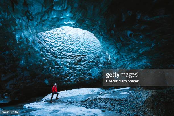 tourist in an ice cave, iceland - höhle stock-fotos und bilder