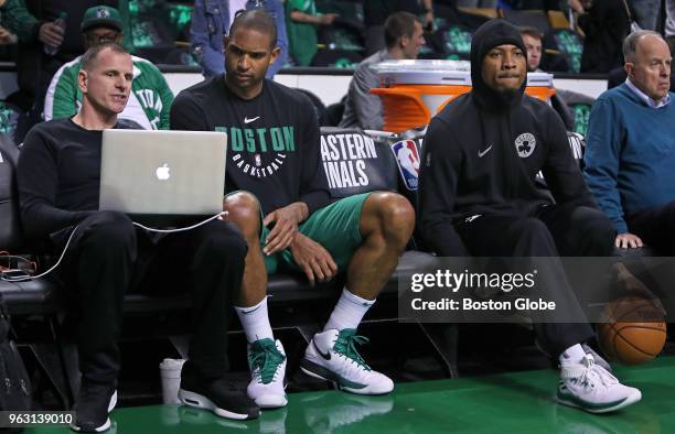 Before the game, Celtics assistant coach Jay Larranaga goes over some strategy on a laptop with Al Horford while Marcus Smart does some seated...