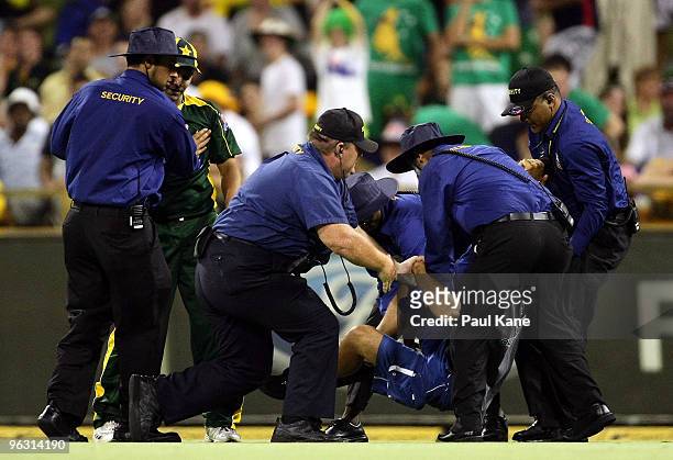 Security grapple with a pitch invader after he tackled Khalid Latif of Pakistan during the fifth One Day International match between Australia and...