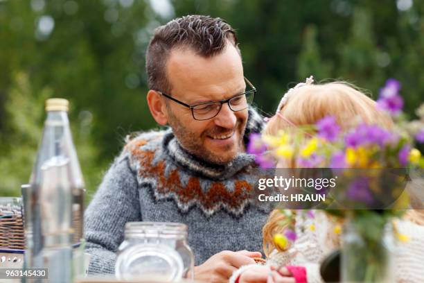 man smiling while looking at daughter in yard - genderblend2015 stock pictures, royalty-free photos & images