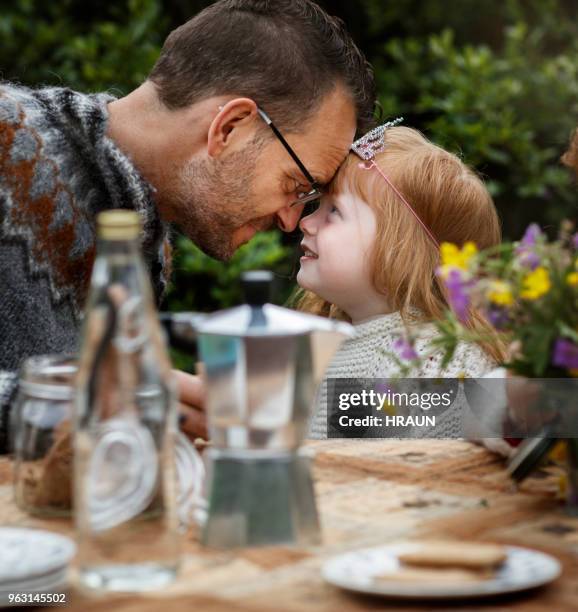 father and daughter touching foreheads in yard - genderblend2015 stock pictures, royalty-free photos & images