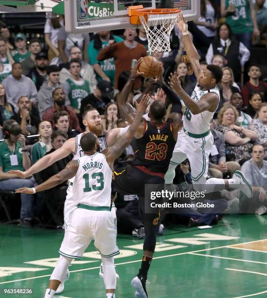 Cleveland Cavaliers Lebron James drives to the basket with pressure from Boston Celtics players Marcus Morris, Aron Baynes and Marus Smart during...