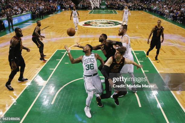 Marcus Smart of the Boston Celtics battles for the ball with Kyle Korver and Jeff Green of the Cleveland Cavaliers in the first half during Game...