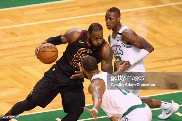 LeBron James of the Cleveland Cavaliers drives to the basket against Terry Rozier and Marcus Morris of the Boston Celtics in the first half during...