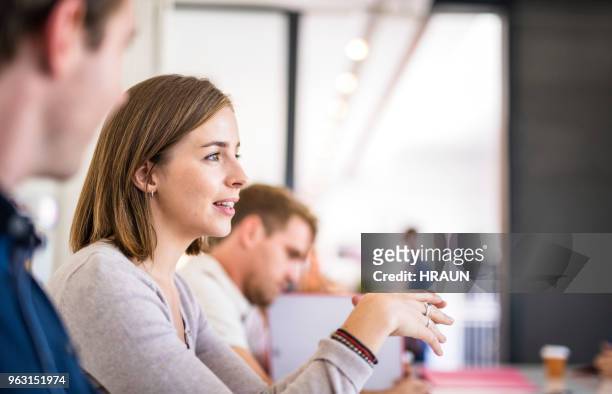 businesswoman discussing with male coworkers - business casual stock pictures, royalty-free photos & images
