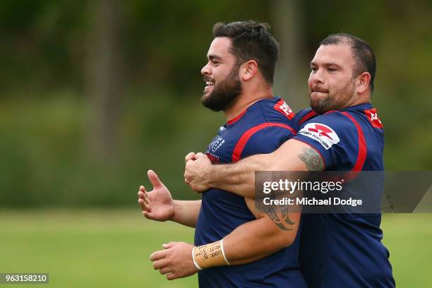 Laurie Weeks gives Jermaine Ainsley a bear hug during a Melbourne Rebels Super Rugby training session at Gosch's Paddock on May 28, 2018 in...