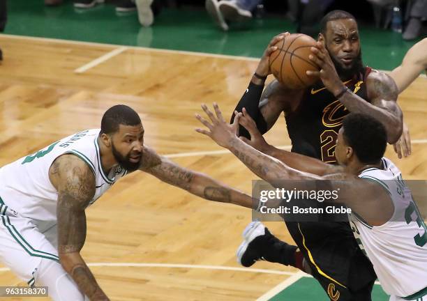 Cleveland Cavaliers LeBron James drives to the basket in between Boston Celtics Marcus Morris and Marcus Smart during fourth quarter action. The...