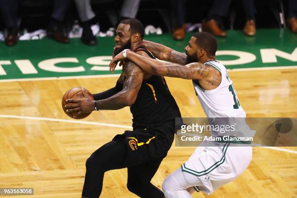 LeBron James of the Cleveland Cavaliers drives to the basket as he is fouled by Marcus Morris of the Boston Celtics in the second half during Game...