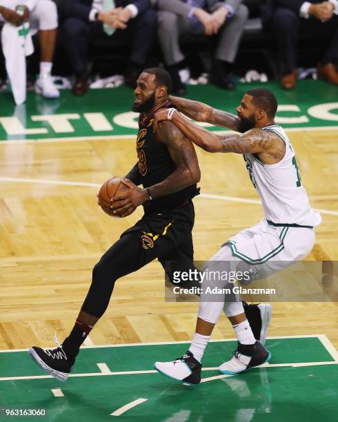 LeBron James of the Cleveland Cavaliers drives to the basket as he is fouled by Marcus Morris of the Boston Celtics in the second half during Game...