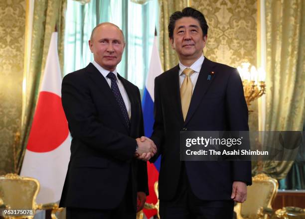 Japanese Prime Minister Shinzo Abe and Russian President Vladimir Putin shake hands prior to their meeting at Kremlin on May 26, 2018 in Moscow,...