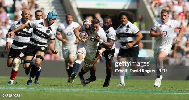 Mark Wilson of England is tackled during the Quilter Cup match between England and the Barbarians at Twickenham Stadium on May 27, 2018 in London,...