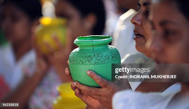 Sri Lankan Buddhist devotees hold water pots as they offer prayers on Poya-full moon at the Kelaniya Temple in Kelaniya, Gampaha district on January...