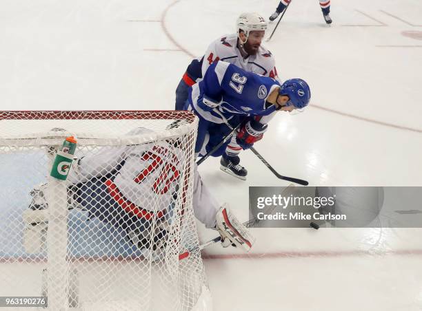 Braden Holtby of the Washington Capitals makes a save against Yanni Gourde of the Tampa Bay Lightning as Brooks Orpik defends in Game Seven of the...