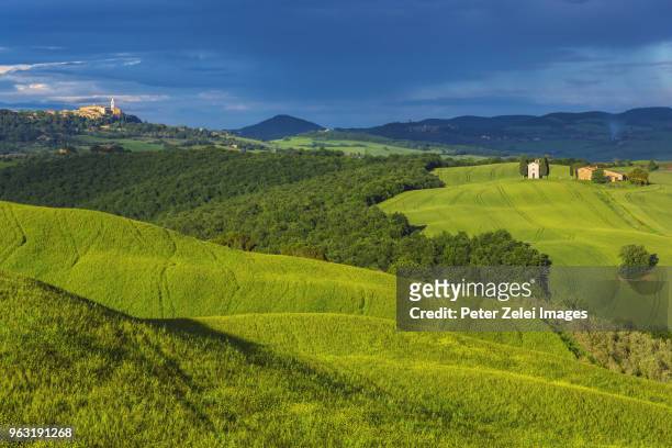tuscan landscape with the small of town of pienza and capella di vitaleta in the distance - capella di vitaleta stock pictures, royalty-free photos & images