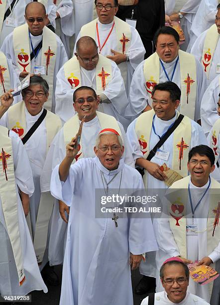 Cardinal Gaudencio Rosales , Archbishop of Manila, waves with his priests as they march on the streets of Manila on January 29 on their way to a...