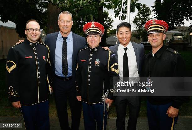 Emmy, Golden Globe and SAG Award-nominated actor John Corbett and Star of Chicago Med Brian Tee pose for a photo with Army servicemen backstage at...