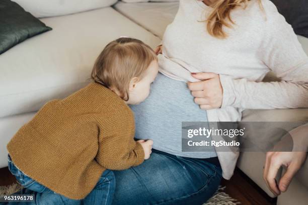 toddler kissing mom's pregnancy belly - belly kissing stock pictures, royalty-free photos & images